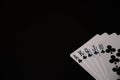 Isolated playing cards with royal flush of clubs poker combination on the black background. Copy space