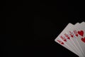 Isolated playing cards with royal flush of hearts poker combination on the black background. Copy space Royalty Free Stock Photo
