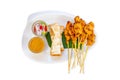 Isolated Pork Satay with coconut milk and bread with sauce in white plastic plate on a white background
