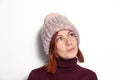 Portrait of beautiful young redhead girl with green eyes pink knitted hat with pompon dressed sideways smiling on white background