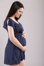 Isolated portrait of pregnant smiling woman in dress waiting for Royalty Free Stock Photo
