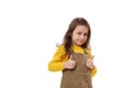 Amazed happy excited Caucasian little child girl showing thumbs up gesture, showing approval sign, excellent feedback.