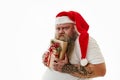 Isolated portrait on a white background of an overweigh man in Santa Claus hat expressing emotions greed and hugging a