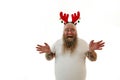 Isolated portrait on a white background of an overweigh man with tattooed arms wearing a hoop with antlers on the head raises palm