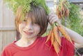 Isolated portrait of a young brunette caucasian holding bunch of carrots