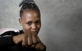 Isolated portrait of young cool and confident black afro American woman in fighting stance looking defiant rising her fist Royalty Free Stock Photo