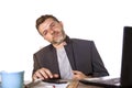 Isolated portrait of young successful and attractive businessman working at office computer desk satisfied and relaxed in