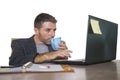 Isolated portrait of young successful and attractive businessman working at office computer desk satisfied and relaxed in