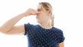 Isolated closeup portrait of young woman feeling bad smell closing her nose with hand Royalty Free Stock Photo