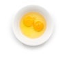 Isolated raw chicken eggs, top view of two raw egg yolk in white bowl on white background Royalty Free Stock Photo