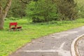 Isolated red bench in the park near an asphalt road Germany, Europe Royalty Free Stock Photo