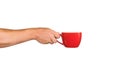 Isolated red mug for coffee, tea in a man& x27;s hand. On a white background Royalty Free Stock Photo