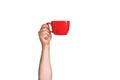 Isolated red mug for coffee, tea in a man's hand. On a white background Royalty Free Stock Photo