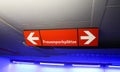 Isolated red neon sign giving direction to parking spaces for women german word: FrauenparkplÃÂ¤tze in underground car park