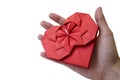 Isolated red paper heart made in origami technique in female hand on a white background. Concept of love, care, health, life