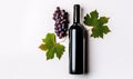 Isolated red wine grapes and a bottle of wine placed on a white background.