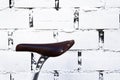 Isolated saddle of an old fixed gear bicycle in a white brick wall Royalty Free Stock Photo