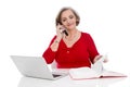 Isolated senior business woman in red calling - sitting at desk.