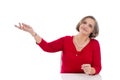 Isolated senior business woman in red presenting with hand. Royalty Free Stock Photo