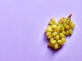 Isolated set of a bunch of sweet seedless grapes in studio with pastel violet background