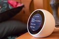 Isolated, shallow focus image of a popular Smart Home personal assistant seen on a bedside table.