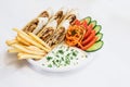 Isolated shawarma in a plate with shadow. Oriental food made from chicken meat, tomatoes, Korean carrots, french fries