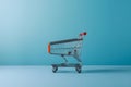 Isolated shopping trolley against calming blue background, minimalist vibe