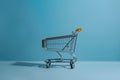 Isolated shopping trolley against calming blue background, minimalist vibe