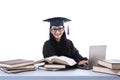 An isolated shot of female graduate with laptop and books Royalty Free Stock Photo