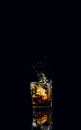 Isolated shot of whiskey with splash on black background Royalty Free Stock Photo