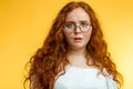 Isolated shot of young funny redhead female stares at camera with shoked expression