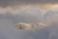 Isolated snowcapped peak among clouds