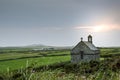 The isolated St Non`s Chapel with the sun setting behind it in Pembrokeshire, Wales