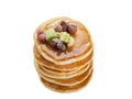 Isolated stack of hot pancakes with nuts, dried fruits and caramel syrup.
