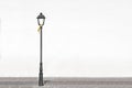 Isolated street light against a white wall on a cobblestone floor for fashion and urban background. No people and empty copy space Royalty Free Stock Photo