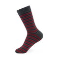 Isolated striped long men`s sock on invisible mannequin foot on white background, side view. Royalty Free Stock Photo