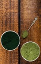 An isolated tablespoon of dried organic wheat grass and spirulina powder, on white rustic background Royalty Free Stock Photo