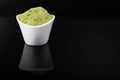 An isolated tablespoon of dried organic wheat grass and spirulina powder, on white rustic background