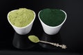 An isolated tablespoon of dried organic wheat grass and spirulina powder, on white rustic background Royalty Free Stock Photo