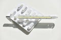 Isolated thermometer and pills on the white background