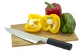 Isolated of three Bell peppers on wooden cutting board with kitchen knife Royalty Free Stock Photo