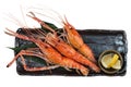 Isolated Top view of Grilled shrimps Giant Tiger Pawn with salt served with sliced lemon in black stone plate