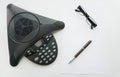Isolated top view of Voip IP conference phone with glasses and pen Royalty Free Stock Photo