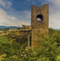 An isolated tower rises above the foliage before the Tower Bridge and fortress at Spoleto, Italy Royalty Free Stock Photo