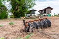 An isolated tractor disc plough is left unused.