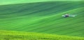 Isolated tractor in green fields