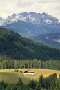 Isolated traditional house in a meadow in the middle of the woods in Austrian Alps, loneliness and quarantine concept, sunny Royalty Free Stock Photo