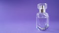 Isolated transparent perfume bottle on purple background. Gift concept. Fragrance spray mock up. Spring scent Royalty Free Stock Photo