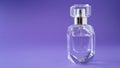 Isolated transparent perfume bottle on purple background. Gift concept. Fragrance spray mock up. Spring scent Royalty Free Stock Photo