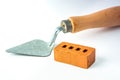 Isolated trowel and brick block on white background